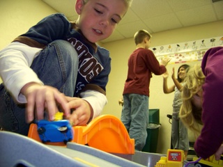 Boy plays with car in Kids Kan Class